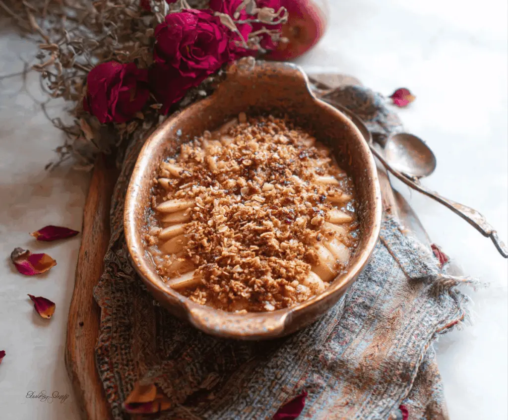 Delicious Rose Water Apple Crisp in a baking dish topped with golden, flaky crust and garnished with fresh rose petals, perfect for a fragrant dessert
