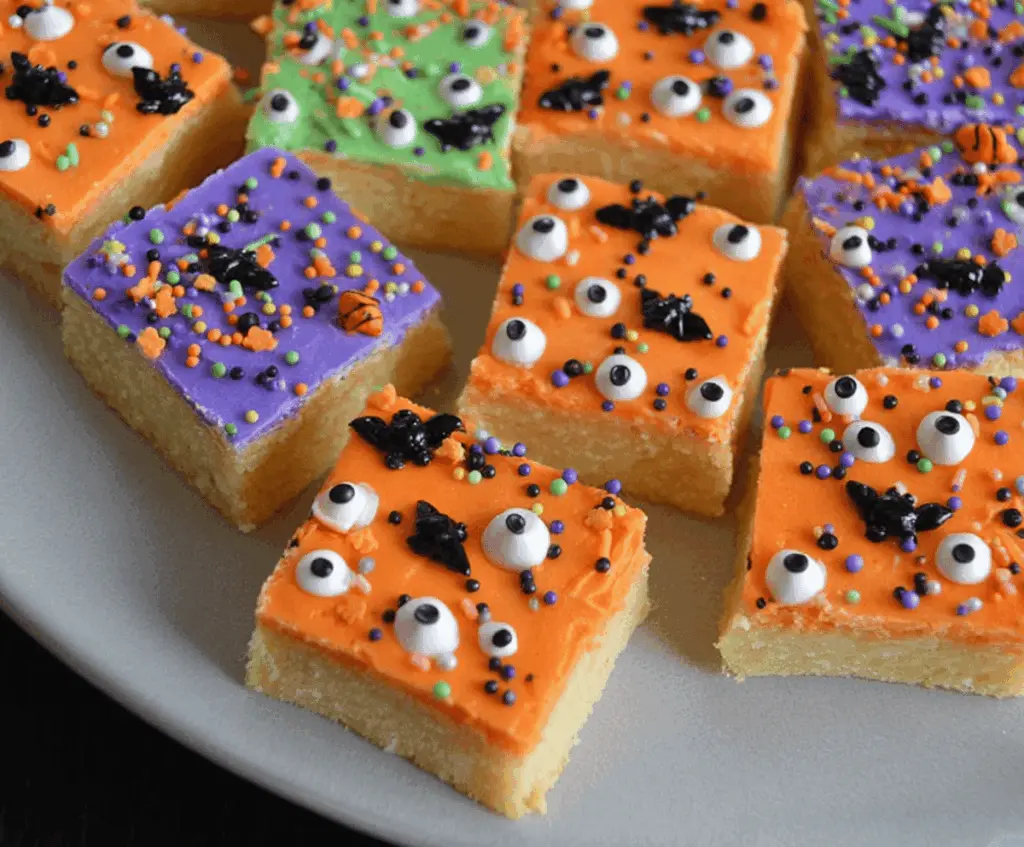 Decorative Halloween Sugar Cookie Bars with colorful icing and spooky Halloween themed toppings on a festive plate.