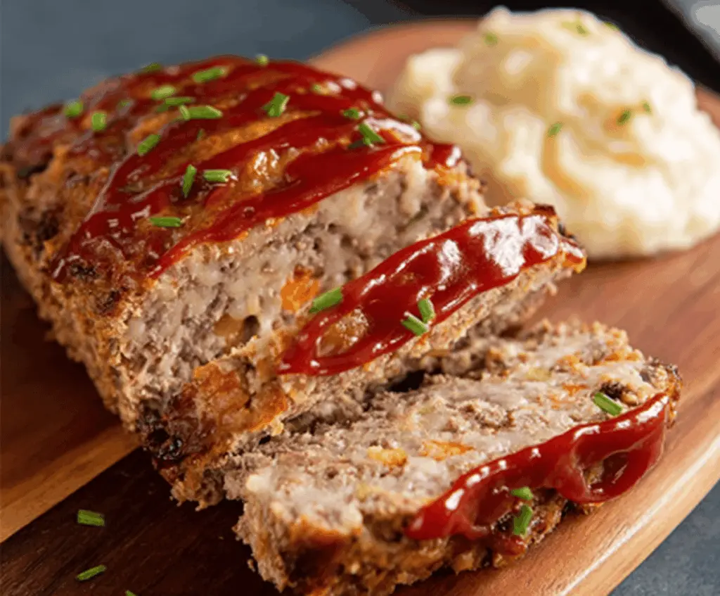 Delicious homemade ranch meatloaf served on a plate with fresh vegetables and mashed potatoes, perfect for a hearty family dinner.