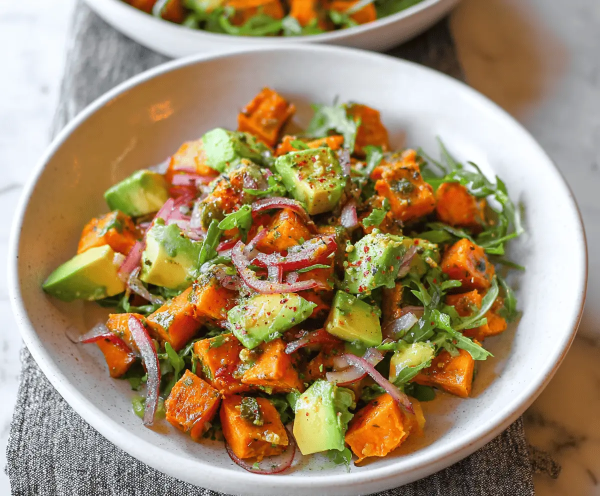 Colorful sweet potato salad with creamy avocado and fresh herbs in a bowl, perfect for healthy meals.