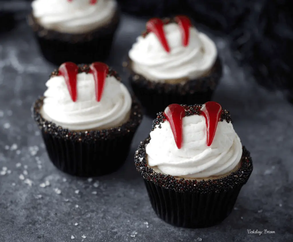 Delicious Vampire Bite Cupcakes with red velvet cake, creamy white frosting, and bloody cherry topping for a spooky Halloween treat