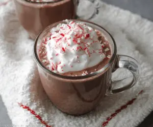 Delicious Crockpot Peppermint Hot Chocolate topped with whipped cream and peppermint candies.