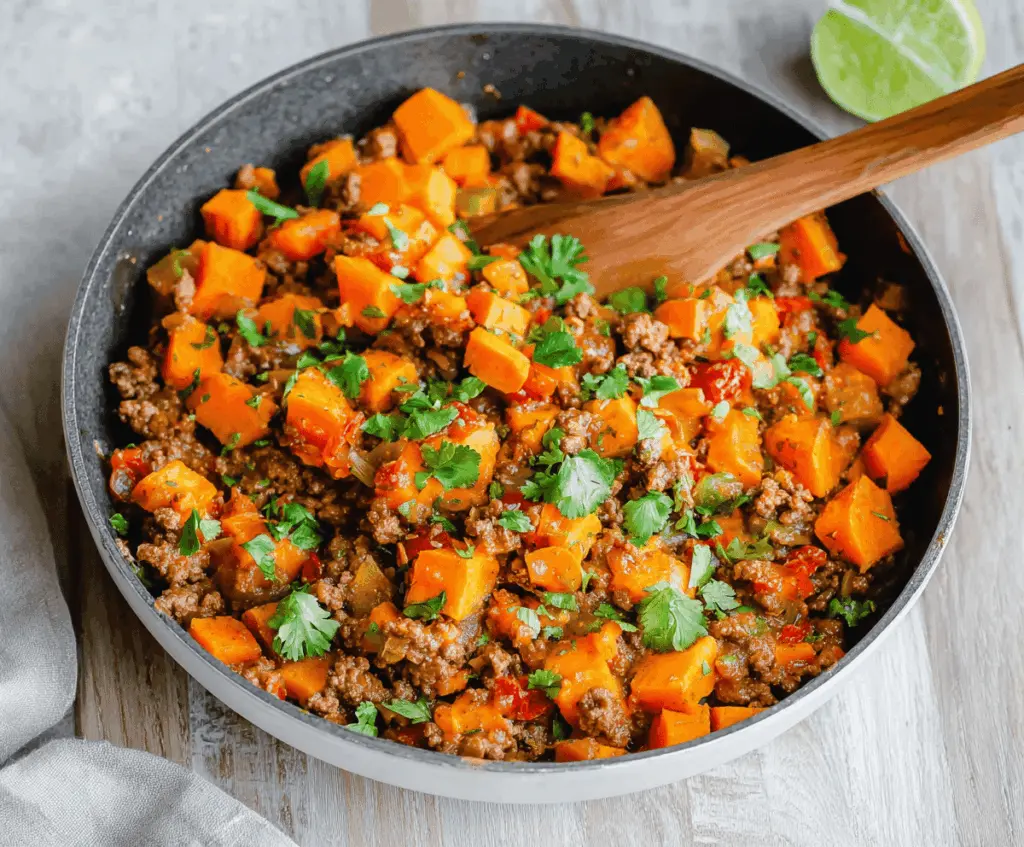 Delicious sweet potato and ground beef skillet with fresh herbs and vegetables.