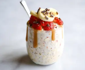 Delicious Banana Split Overnight Oats topped with fresh bananas, strawberries, and a drizzle of chocolate syrup.
