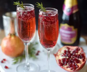 Refreshing Pomegranate Prosecco Cocktail in a glass garnished with pomegranate seeds and a slice of lime