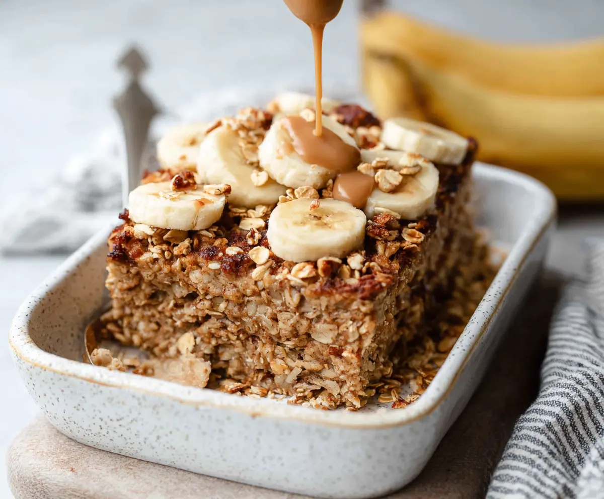 Delicious Banana Bread Baked Oatmeal served in a baking dish with ripe bananas and a golden crust.