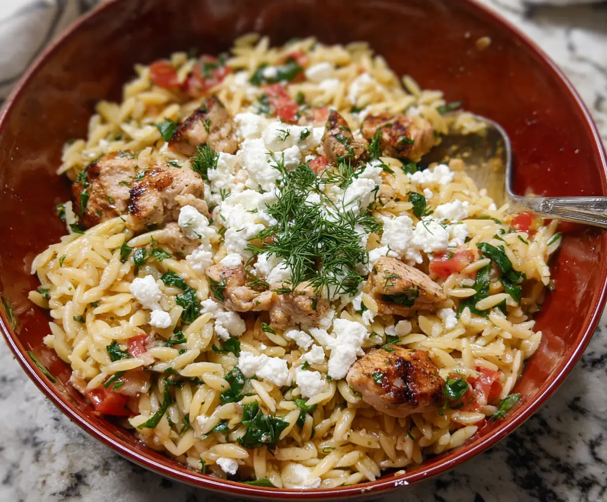 Delicious feta orzo with grilled chicken, fresh herbs, and a creamy sauce, perfect for a quick lunch or dinner.