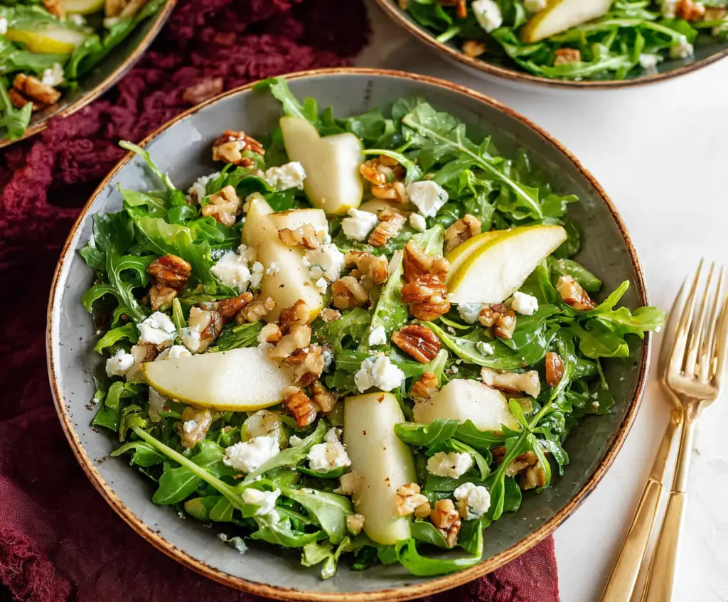 Fresh arugula and ripe pear salad drizzled with vinaigrette, perfect for a healthy meal.