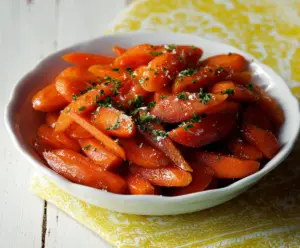 Sweet candied carrots garnished with nuts, perfect as a festive dessert or side dish.