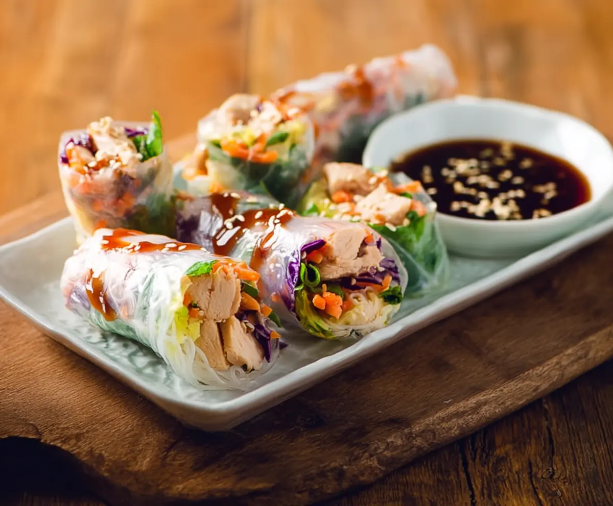 Delicious Teriyaki Chicken Rice Paper Rolls with fresh vegetables and dipping sauce.